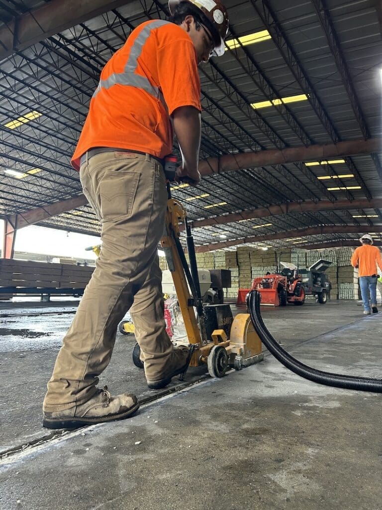 Man cleaning an concrete expansion joint for repair