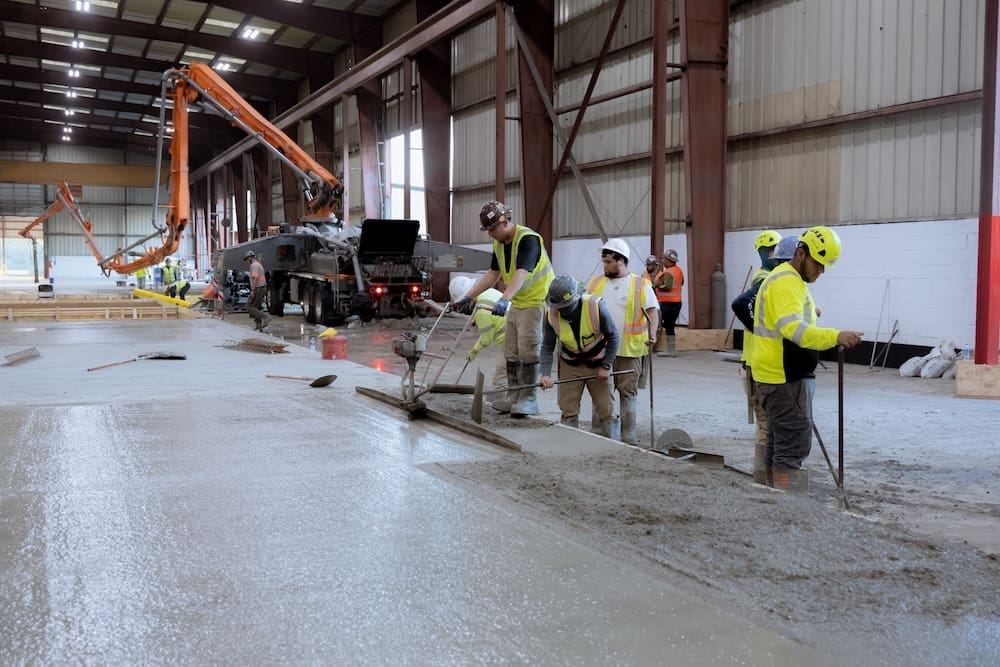 Men manually screeding a concrete slab